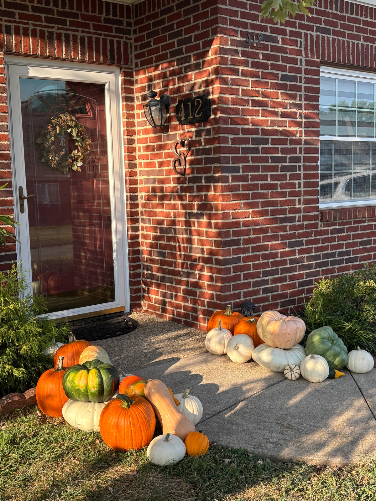 Small front porch decorated with pumpkins and fall accents